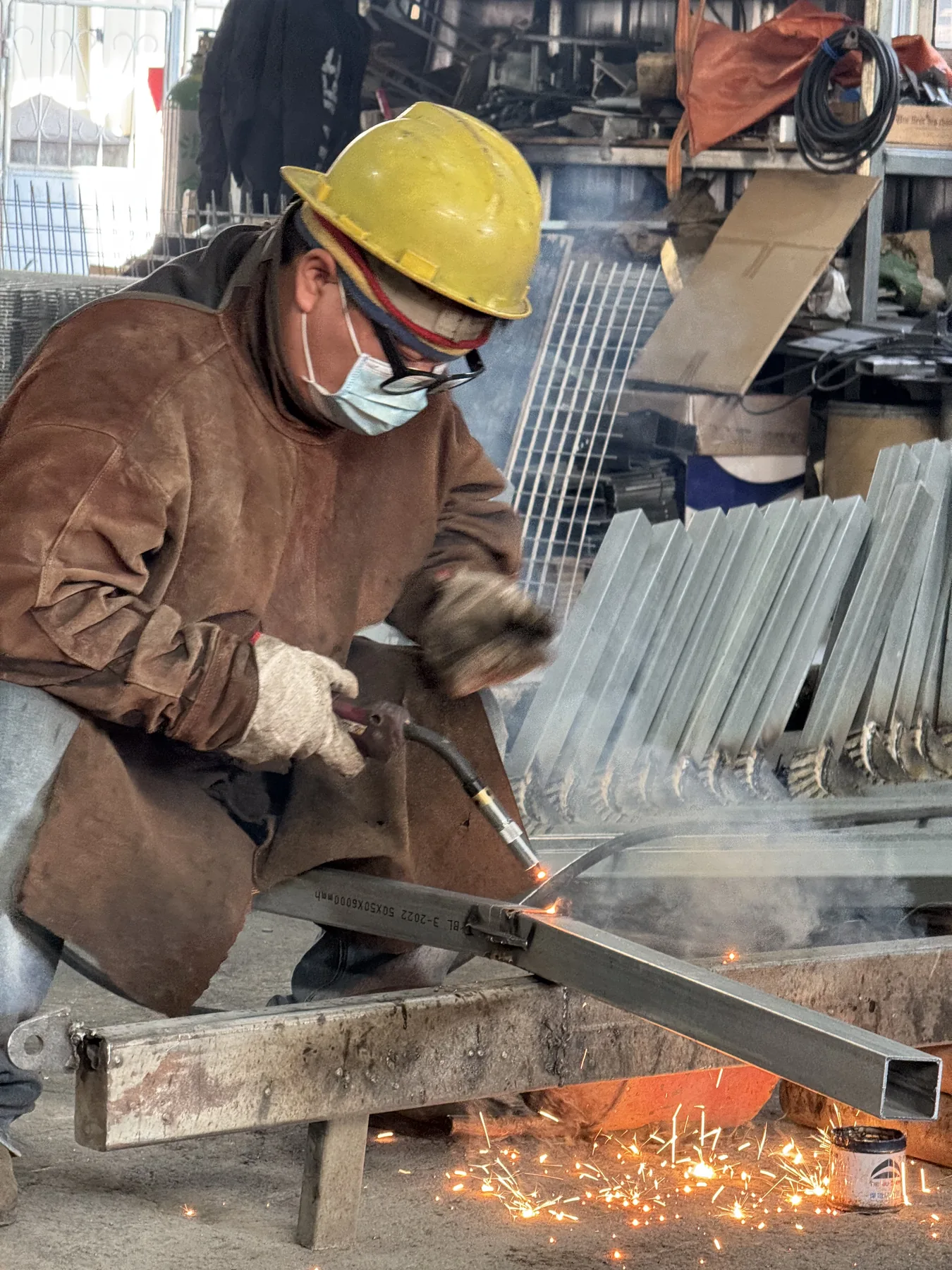 Worker welding steel components for padel court structure